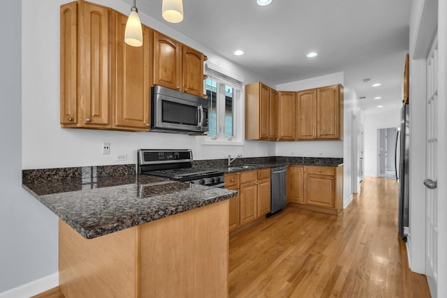 7153 W Irving Park Rd Unit 3, Chicago, IL 60634 - kitchen with appliances with stainless steel finishes, a peninsula, light wood-style flooring, dark stone countertops, and hanging light fixtures
