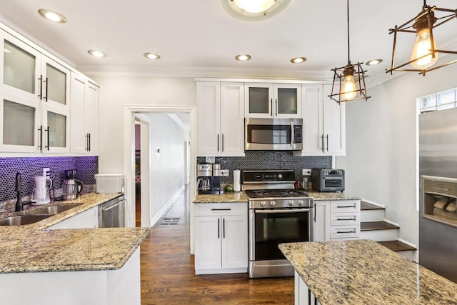 5639 W Cornelia Ave, Chicago, IL 60634 - kitchen with appliances with stainless steel finishes, ornamental molding, tasteful backsplash, light stone counters, and white cabinetry