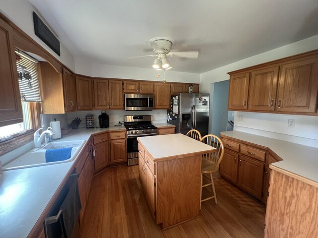 24005 S Green Heron Dr, Channahon, IL 60410 - kitchen with stainless steel appliances, dark wood-style floors, light countertops, a ceiling fan, and a center island