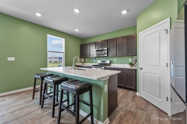 1360 Vineyard Ln, Pingree Grove, IL 60140 - kitchen with stainless steel appliances, a kitchen bar, a kitchen island with sink, light wood finished floors, and recessed lighting