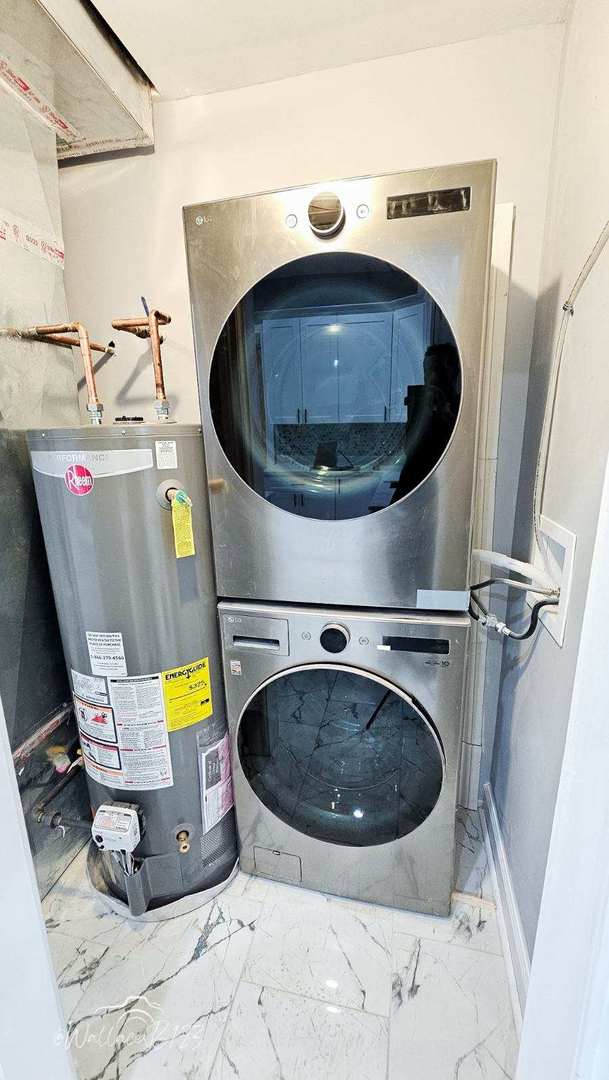 5309 S Bishop St, Chicago, IL 60609 - laundry area with stacked washer / drying machine, gas water heater, and marble finish floors