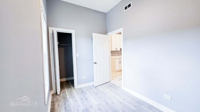5309 S Bishop St, Chicago, IL 60609 - unfurnished bedroom with a walk in closet, light wood finished floors, and a closet