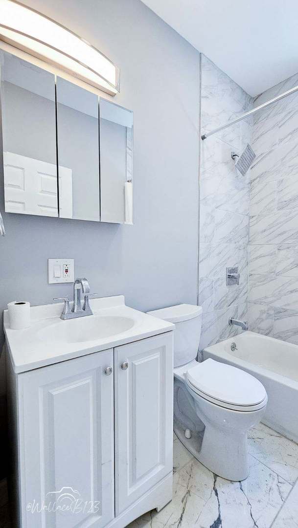 5309 S Bishop St, Chicago, IL 60609 - full bathroom with marble finish flooring, vanity, and washtub / shower combination