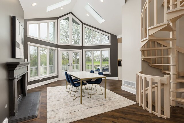 7 Loblolly Ct, Lemont, IL 60439 - dining area with high vaulted ceiling, french doors, a skylight, a fireplace with raised hearth, and dark wood-style floors