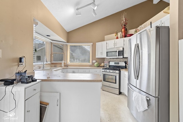 3411 Harris Dr, Joliet, IL 60431 - kitchen featuring stainless steel appliances, vaulted ceiling, a peninsula, white cabinetry, and light countertops