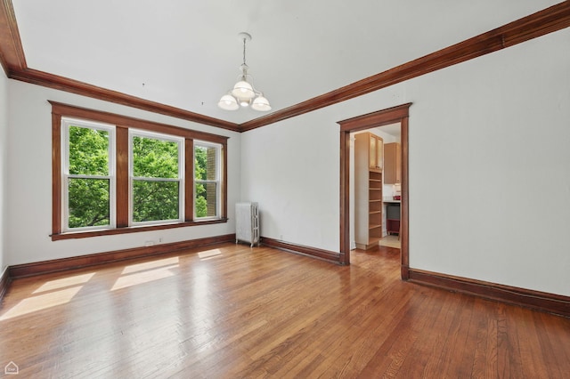 1235 E 53rd St Unit 3, Chicago, IL 60615 - empty room with radiator, a chandelier, ornamental molding, and hardwood / wood-style flooring