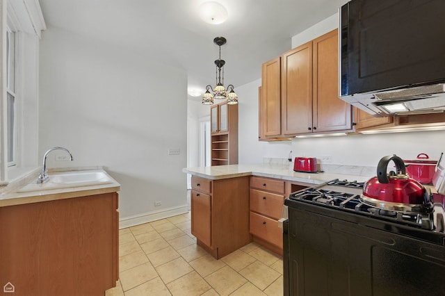 1235 E 53rd St Unit 3, Chicago, IL 60615 - kitchen with black appliances, a peninsula, light countertops, light tile patterned floors, and decorative light fixtures