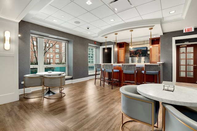 57 E Delaware Pl Unit 2901, Chicago, IL 60611 - dining area with a bar, wood finished floors, a paneled ceiling, a tray ceiling, and a textured wall