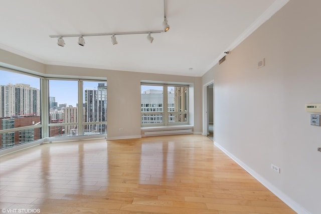 57 E Delaware Pl Unit 2901, Chicago, IL 60611 - empty room with rail lighting, a baseboard radiator, light wood-type flooring, and ornamental molding