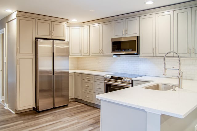 535 E Jefferson St Unit 2C, Bensenville, IL 60106 - kitchen featuring appliances with stainless steel finishes, a peninsula, light countertops, recessed lighting, and light wood-type flooring