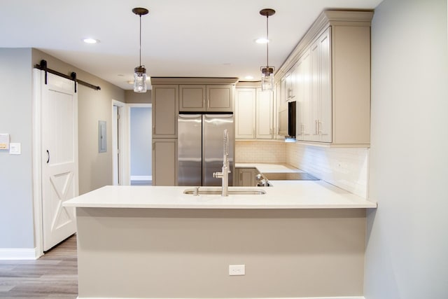 535 E Jefferson St Unit 2C, Bensenville, IL 60106 - kitchen featuring freestanding refrigerator, a barn door, a peninsula, decorative backsplash, and light countertops