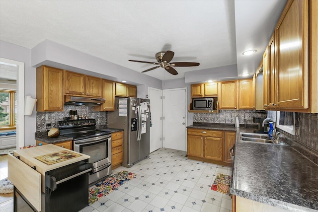 302 S Orr Dr, Normal, IL 61761 - kitchen featuring appliances with stainless steel finishes, ceiling fan, under cabinet range hood, dark countertops, and tasteful backsplash