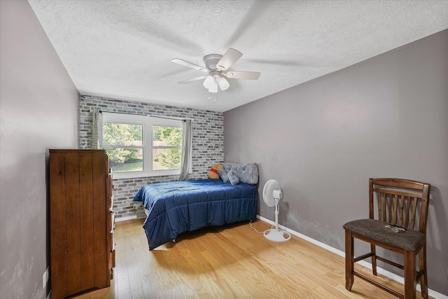 302 S Orr Dr, Normal, IL 61761 - bedroom with light wood finished floors, a textured ceiling, ceiling fan, and brick wall