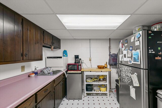 302 S Orr Dr, Normal, IL 61761 - kitchen with freestanding refrigerator, a paneled ceiling, light floors, dark brown cabinetry, and light countertops