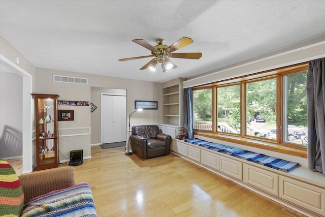 302 S Orr Dr, Normal, IL 61761 - living area with light wood-style flooring, ceiling fan, a textured ceiling, and built in shelves