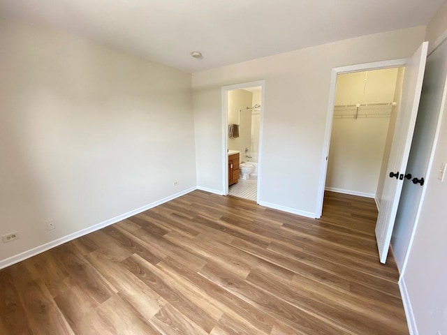 1340 Mcdowell Rd Unit 201, Naperville, IL 60563 - unfurnished bedroom with wood finished floors, a closet, a walk in closet, and connected bathroom