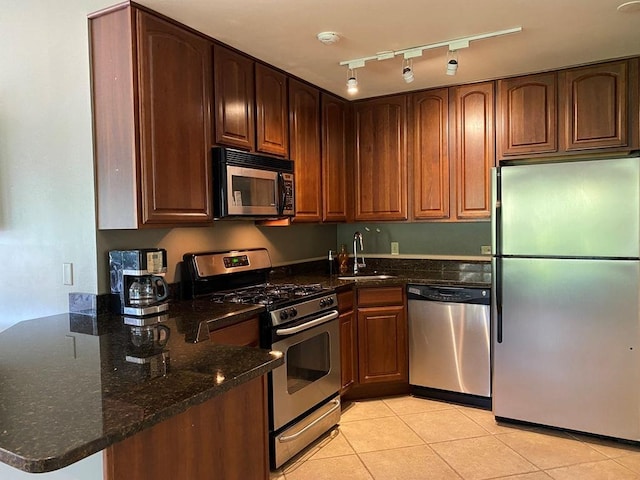 1340 Mcdowell Rd Unit 201, Naperville, IL 60563 - kitchen with appliances with stainless steel finishes, dark stone countertops, light tile patterned floors, a peninsula, and track lighting