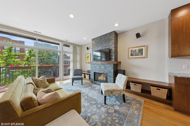 2033 N Damen Ave Unit 2N, Chicago, IL 60647 - living room featuring a stone fireplace, light wood-style flooring, and recessed lighting