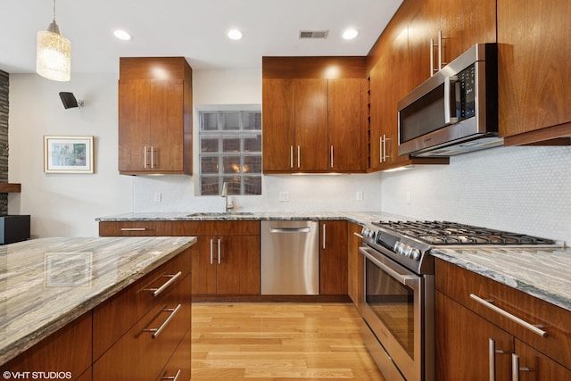 2033 N Damen Ave Unit 2N, Chicago, IL 60647 - kitchen with stainless steel appliances, light stone countertops, light wood-style floors, decorative backsplash, and recessed lighting