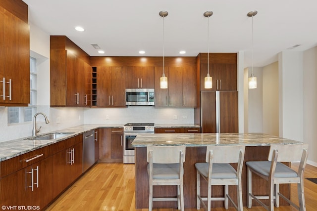 2033 N Damen Ave Unit 2N, Chicago, IL 60647 - kitchen featuring stainless steel appliances, light wood-style flooring, tasteful backsplash, light stone countertops, and recessed lighting