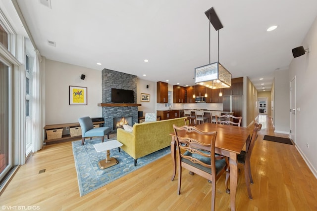 2033 N Damen Ave Unit 2N, Chicago, IL 60647 - dining area featuring a fireplace, light wood-type flooring, plenty of natural light, and recessed lighting