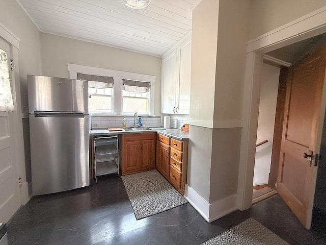 207 College Ave, Dixon, IL 61021 - kitchen with freestanding refrigerator, brown cabinetry, light countertops, backsplash, and beverage cooler