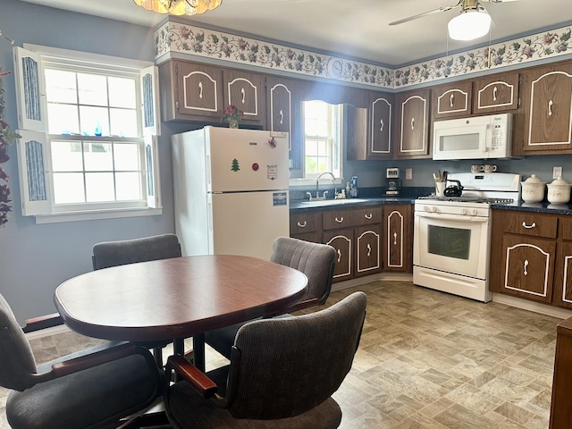 411 1st Ave, Ottawa, IL 61350 - kitchen with white appliances, dark countertops, and dark brown cabinetry