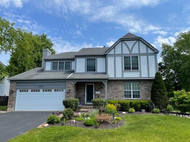 747 Warwick Ct, Carol Stream, IL 60188 - view of front of property featuring a garage, a chimney, a front lawn, asphalt driveway, and brick siding