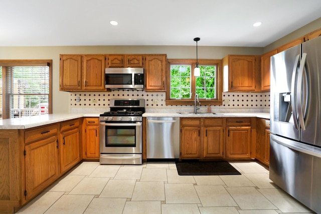747 Warwick Ct, Carol Stream, IL 60188 - kitchen with stainless steel appliances, brown cabinetry, a peninsula, light countertops, and recessed lighting