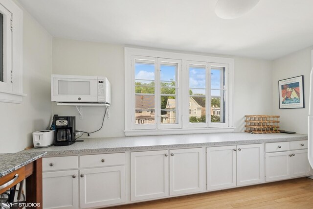235 S Grove Ave, Oak Park, IL 60302 - kitchen featuring white microwave, white cabinets, light countertops, and light wood-style flooring