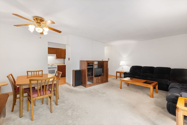dining room featuring ceiling fan and light colored carpet