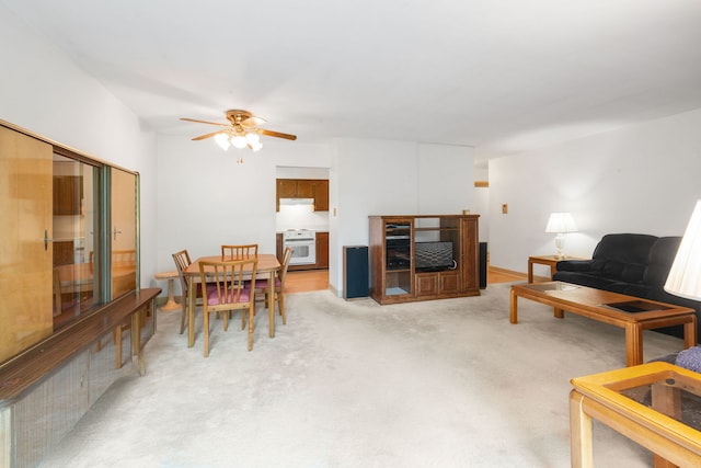 living room with a ceiling fan and light carpet