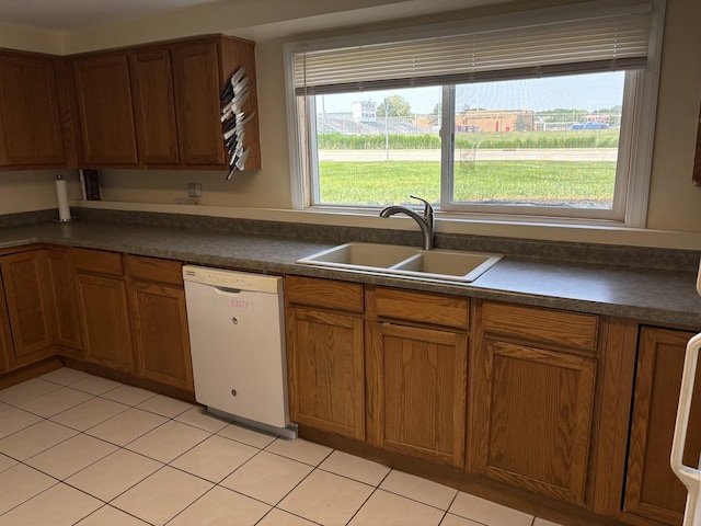 535 N Midlothian Rd, Mundelein, IL 60060 - kitchen with dishwasher, dark countertops, light tile patterned floors, brown cabinetry, and plenty of natural light