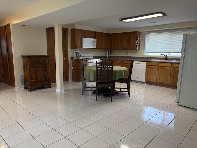 535 N Midlothian Rd, Mundelein, IL 60060 - kitchen featuring white appliances, light tile patterned floors, dark countertops, and brown cabinets
