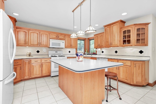 15501 116th Ct, Orland Park, IL 60467 - kitchen with white appliances, a breakfast bar, a center island, light countertops, and backsplash