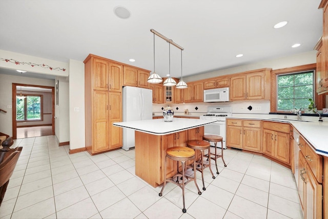 15501 116th Ct, Orland Park, IL 60467 - kitchen with white appliances, a kitchen island, a breakfast bar area, light countertops, and recessed lighting
