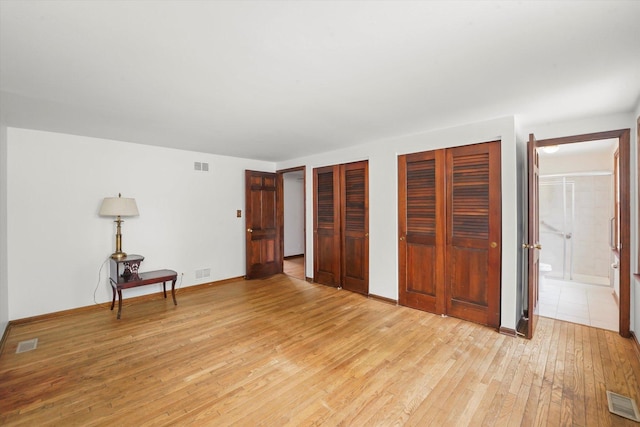 1554 Chickasaw Dr, Naperville, IL 60563 - unfurnished bedroom featuring light wood-style flooring, multiple closets, and ensuite bathroom