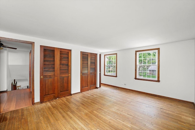 1554 Chickasaw Dr, Naperville, IL 60563 - unfurnished bedroom featuring two closets and light wood-style flooring