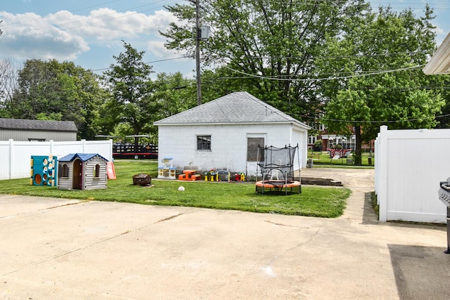 109 E Seminole St, Dwight, IL 60420 - view of home's exterior featuring roof with shingles, an outdoor fire pit, a trampoline, concrete block siding, and an outdoor structure