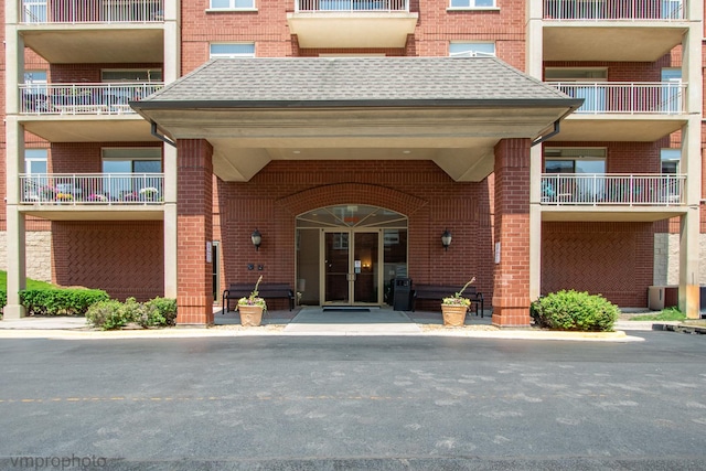 8440 Callie Ave Unit 410, Morton Grove, IL 60053 - view of exterior entry with brick siding and a shingled roof