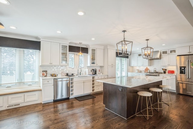 6140 Ruby St, Rosemont, IL 60018 - kitchen featuring appliances with stainless steel finishes, wall chimney range hood, decorative backsplash, white cabinetry, and recessed lighting
