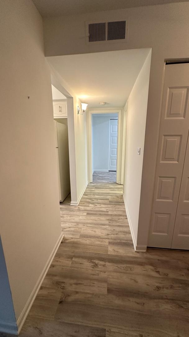 9530 Lamon Ave Unit 104, Skokie, IL 60077 - corridor featuring wood finished floors and baseboards