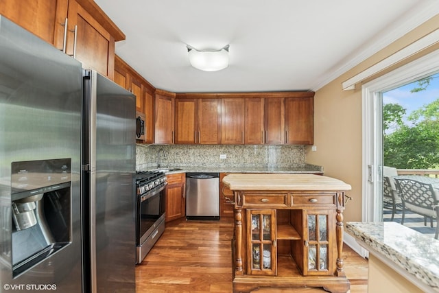 320 Pleasant St, Hoffman Estates, IL 60169 - kitchen featuring appliances with stainless steel finishes, wood finished floors, tasteful backsplash, brown cabinetry, and light stone countertops
