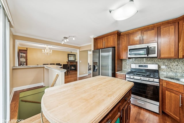 320 Pleasant St, Hoffman Estates, IL 60169 - kitchen featuring stainless steel appliances, a chandelier, ornamental molding, and brown cabinetry