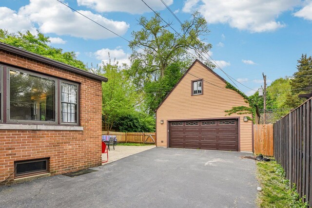 237 Le Grande Blvd, Aurora, IL 60506 - view of side of home with an outdoor structure, a detached garage, and brick siding