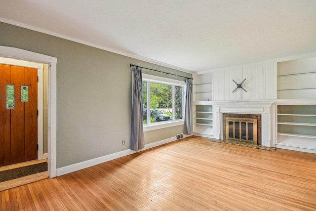 237 Le Grande Blvd, Aurora, IL 60506 - unfurnished living room with wood finished floors, ornamental molding, a fireplace with flush hearth, and built in features