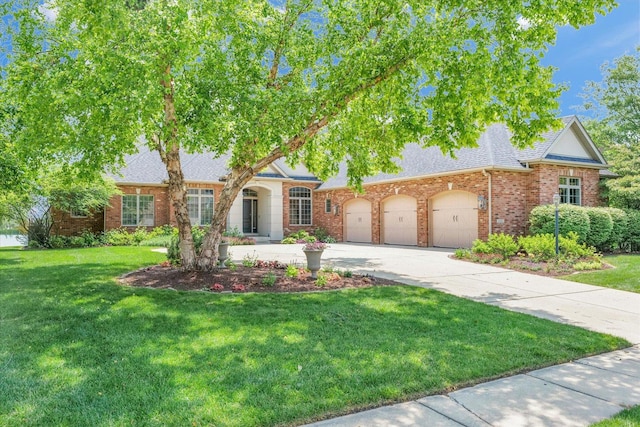 4905 Peifer Ln, Champaign, IL 61822 - view of front of home with a front yard, driveway, a shingled roof, and brick siding