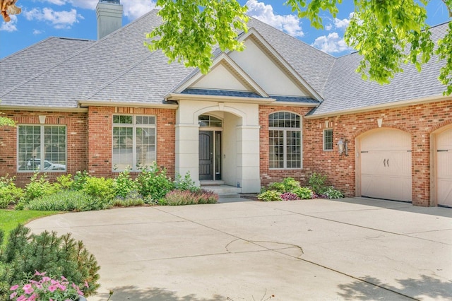 4905 Peifer Ln, Champaign, IL 61822 - view of front of house with brick siding, concrete driveway, roof with shingles, a chimney, and an attached garage