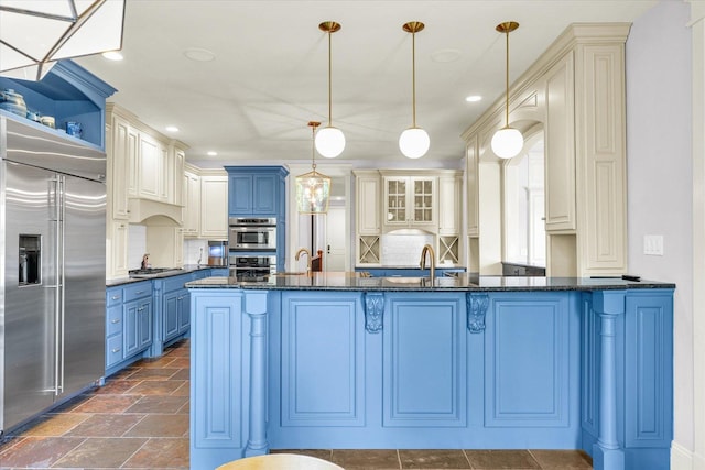 4905 Peifer Ln, Champaign, IL 61822 - kitchen featuring appliances with stainless steel finishes, blue cabinetry, pendant lighting, tasteful backsplash, and dark stone counters