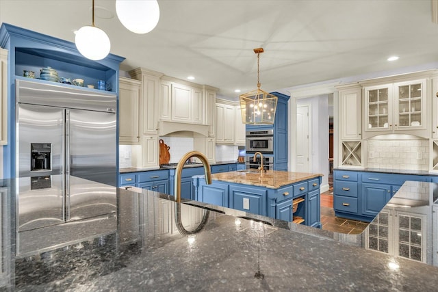 4905 Peifer Ln, Champaign, IL 61822 - kitchen with appliances with stainless steel finishes, blue cabinetry, tasteful backsplash, dark stone countertops, and glass insert cabinets